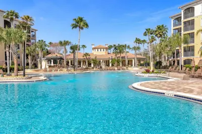 a swimming pool at a resort with palm trees at WorldQuest Resort in Orlando