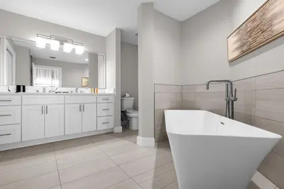 a white bathroom with a tub and a sink at WorldQuest Resort in Orlando
