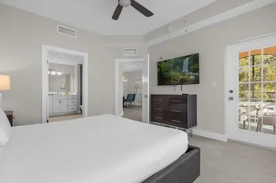 a white bedroom with a bed and a flat screen tv at WorldQuest Resort in Orlando