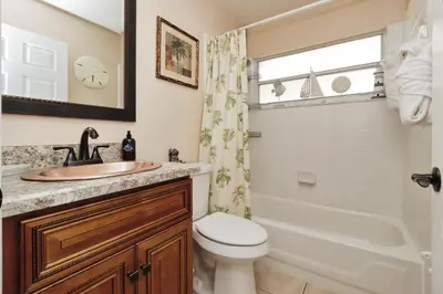 a bathroom with a sink and a toilet and a tub at Ideal for Couples or Families looking for a Vacation Home with Private Pool and Yard in Kissimmee