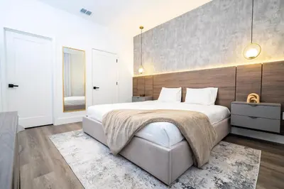 a bedroom with a large bed with a wooden wall at Doppio Westside in Orlando