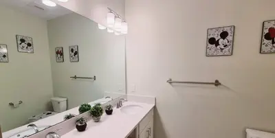 a white bathroom with a sink and a mirror at Stunning Storey Lake Resort and Game room in Kissimmee