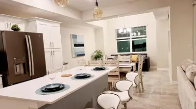 a kitchen and living room with a counter and chairs at Stunning Storey Lake Resort and Game room in Kissimmee