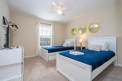 a bedroom with two beds and a tv and a window at Nice Vacation Townhouse w Pool SL4893 in Kissimmee