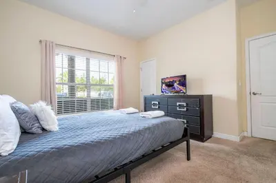 a bedroom with a bed with a dresser and a window at Nice Vacation Townhouse w Pool SL4893 in Kissimmee
