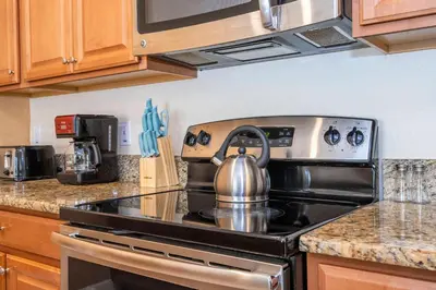 a tea kettle sitting on top of a stove in a kitchen at Nice Vacation Townhouse w Pool SL4893 in Kissimmee