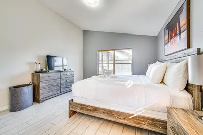 a bedroom with a large white bed and a dresser at 8 Mi to Disney Parks Poolside Paradise! in Kissimmee