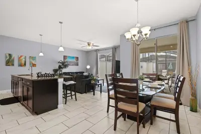 a dining room and living room with a table and chairs at Spacious 4BR Townhome with Pool at Storey Lake in Kissimmee