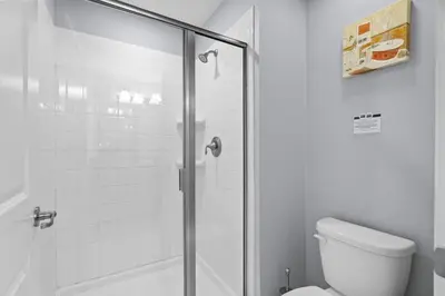 a bathroom with a shower and a toilet at Spacious 4BR Townhome with Pool at Storey Lake in Kissimmee
