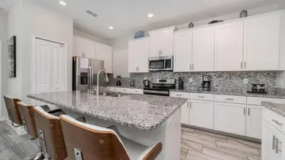 a kitchen with white cabinets and a granite counter top at KCC 4797 in Kissimmee