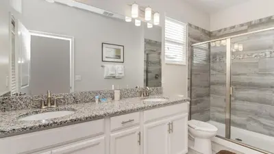 a white bathroom with two sinks and a shower at KCC 4797 in Kissimmee