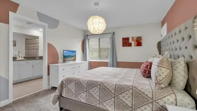 a bedroom with a bed and a dresser and a mirror at QTS4361 in Kissimmee