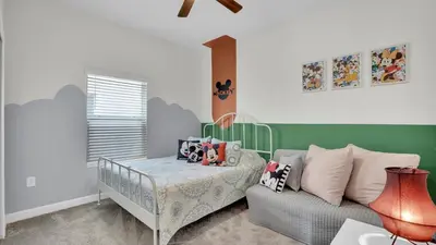 a childs bedroom with a crib and a couch at QTS4361 in Kissimmee