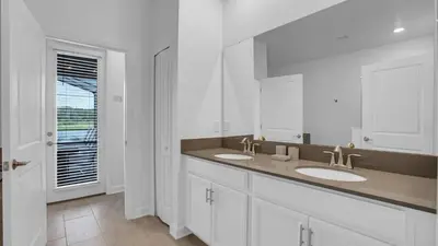 a white bathroom with two sinks and a window at PGD4169 in Kissimmee