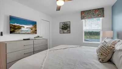 a bedroom with a bed and a dresser and a window at PGD4169 in Kissimmee