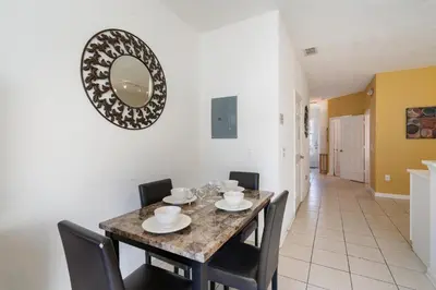 a dining room with a table and chairs and a mirror at Windsor Hills 3 Bedroom Private Pool Townhome 0866 in Orlando