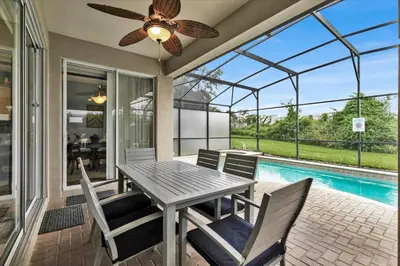 a patio with a table and chairs and a pool at Windsor Hills Resort 5 Bedroom Updated Pool Home 0853 in Orlando