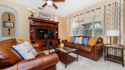 a living room with two leather couches and a tv at Windsor Hills Resort 6 Bedroom Home Incredible Game Room 0852 in Orlando
