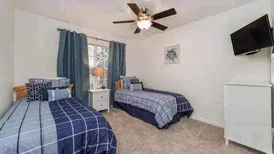 a bedroom with two beds and a ceiling fan at Windsor Hills Resort 5 Bedroom Home with Game Room 0851 in Orlando