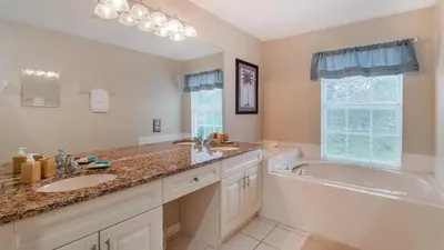 a bathroom with a tub and a sink and a tub and a bath tub at Windsor Palms Resort 6 Bedroom with Game Room 0847 in Kissimmee