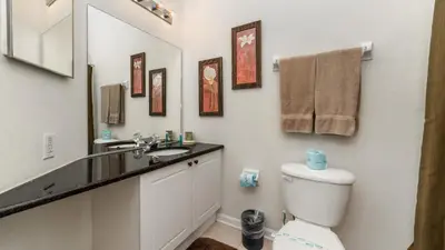 a bathroom with a toilet and a sink and a mirror at Windsor Palms Resort 6 Bedroom with Pool Spa 0877 in Kissimmee