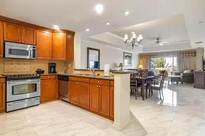 a kitchen with wooden cabinets and a dining room at AQ0401 Villas North Charm in Orlando