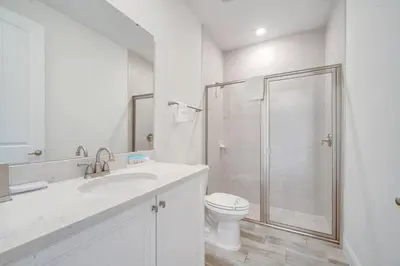 a white bathroom with a shower and a toilet at Just Lauched - Luxury & Cozy 3BR near Disney-Margaritaville in Orlando