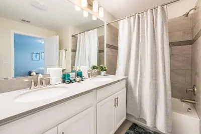 a white bathroom with a sink and a shower at casa 4Q com piscina Mickey & Star Wars! in Kissimmee