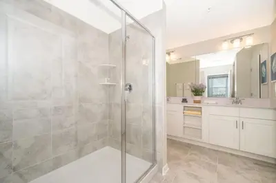 a bathroom with a shower with a glass door at Aconchegante 2Q no Storey Lake – 10 min da Disney! in Kissimmee