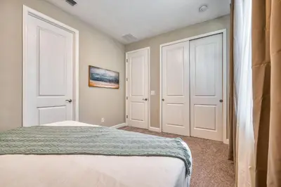 a bedroom with two white doors and a bed at Villa Luxuosa | 4 Quartos | Perto da Disney! in Orlando