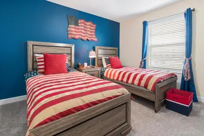 two beds in a bedroom with blue walls at Villa Kerpen - Storey Lake in Kissimmee