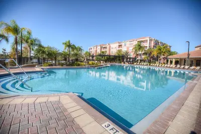 a large swimming pool with palm trees and buildings at 5014 Tideview Circle 9 in Orlando