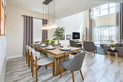a dining room and living room with a table and chairs at Luxo Moderno | 5Q | Piscina | Perto da Disney in Kissimmee