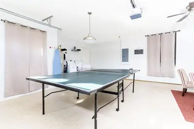 a ping pong table in a room with two chairs at Villa Helena, Windsor Palms in Kissimmee