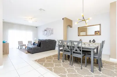 a dining room and living room with a table and chairs at Villa Helena, Windsor Palms in Kissimmee