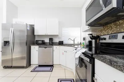 a kitchen with stainless steel appliances and white cabinets at Villa Helena, Windsor Palms in Kissimmee