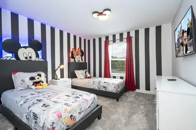 a bedroom with two beds and a striped wall at Villa Smile, Storey Lake in Kissimmee