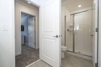 a white bathroom with a toilet and a shower at Villa Smile, Storey Lake in Kissimmee