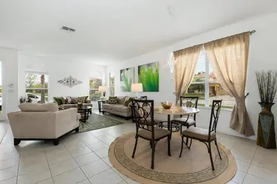 a living room with a table and chairs at Villa Martins, Bella Vida in Kissimmee