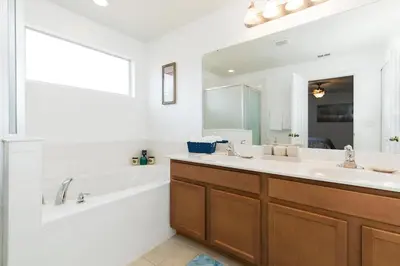 a bathroom with a tub and a sink and a tub and a mirror at Villa Martins, Bella Vida in Kissimmee