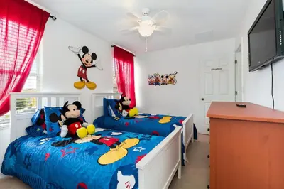 a bedroom with two twin beds with mickey characters on them at Villa Martins, Bella Vida in Kissimmee