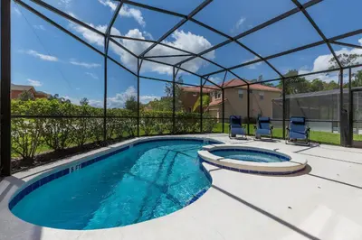 a swimming pool with a pergola and two chairs at Villa Martins, Bella Vida in Kissimmee