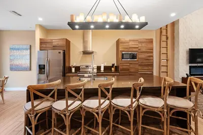 a kitchen with a table with chairs and a refrigerator at 4BD and 4.5BA Amazing Villa with Private Hot Tub (3091) in Orlando