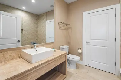 a bathroom with a white sink and a toilet at 4BD and 4.5BA Amazing Villa with Private Hot Tub (3091) in Orlando