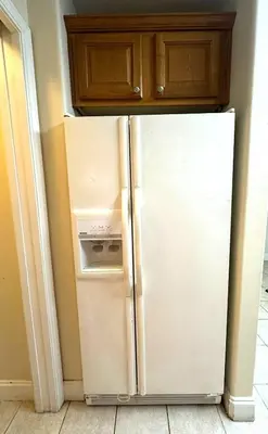 a white refrigerator in a kitchen with wooden cabinets at Heron Lake in Orlando