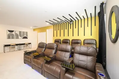 a room with a leather couch and a wall with baseball bats at Brand New 12BR Disney Mansion Pool Spa Game Room in Kissimmee