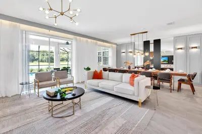 a living room with a white couch and a table at Brand New Luxury 9BR Villa Pool Spa Game Room in Kissimmee