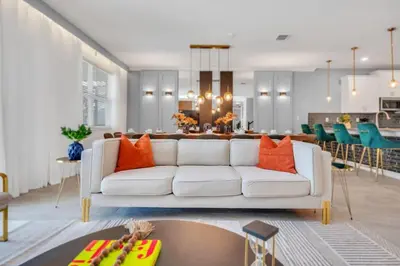 a living room with a white couch and a table at Brand New Luxury 9BR Villa Pool Spa Game Room in Kissimmee
