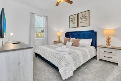 a bedroom with a blue and white bed and a window at Brand New Storey Lake 10 Bedroom Villa with Pool in Kissimmee