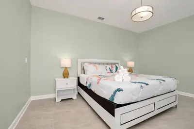 a white bedroom with a bed with two stuffed animals on it at Brand New Storey Lake 8BR Villa with Lake View in Kissimmee